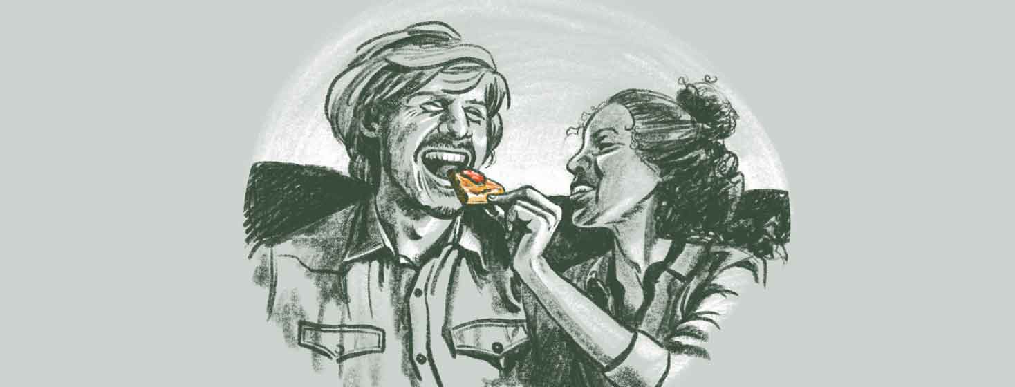 a woman feeds a man a piece of pizza while they laugh